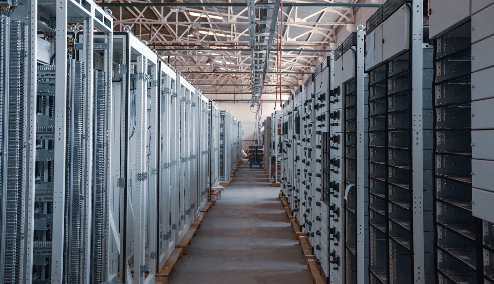 Rows of electrical switchgear lineups being installed in a data-center hall